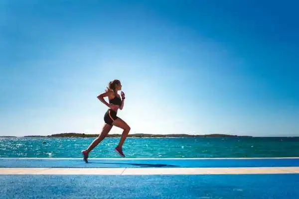 Woman running showing strong leg muscle Busby